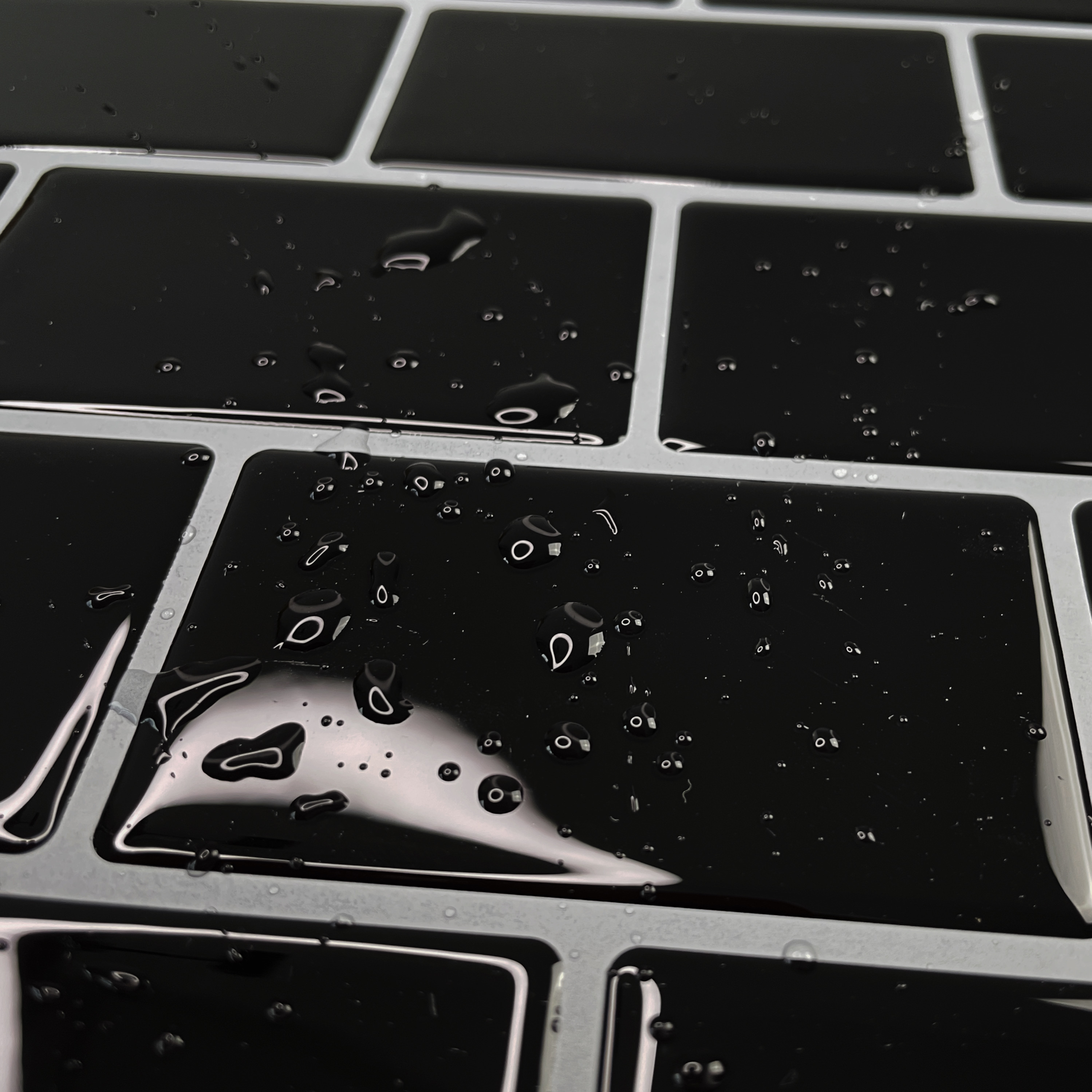 Részletes fénykép a vízzel felázott öntapadós 3D csempéről - fekete téglák